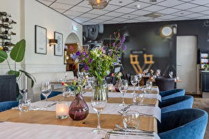 Restaurant in Media Park Hilversum met een opvallende muurschildering van een opname set en een grote eettafel met leren stoelen