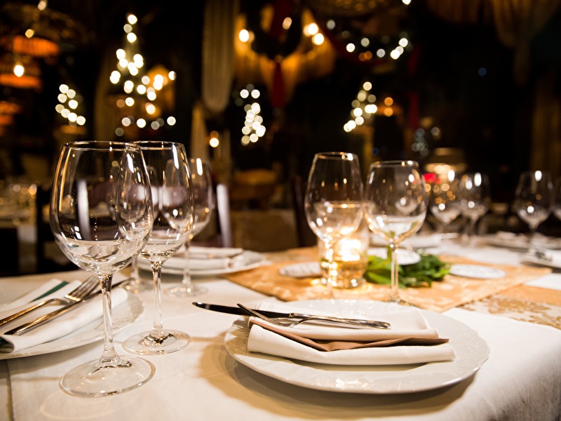 Mooie sfeervolle opgedekte tafel, met glazen en witte borden klaar voor een heerlijk diner