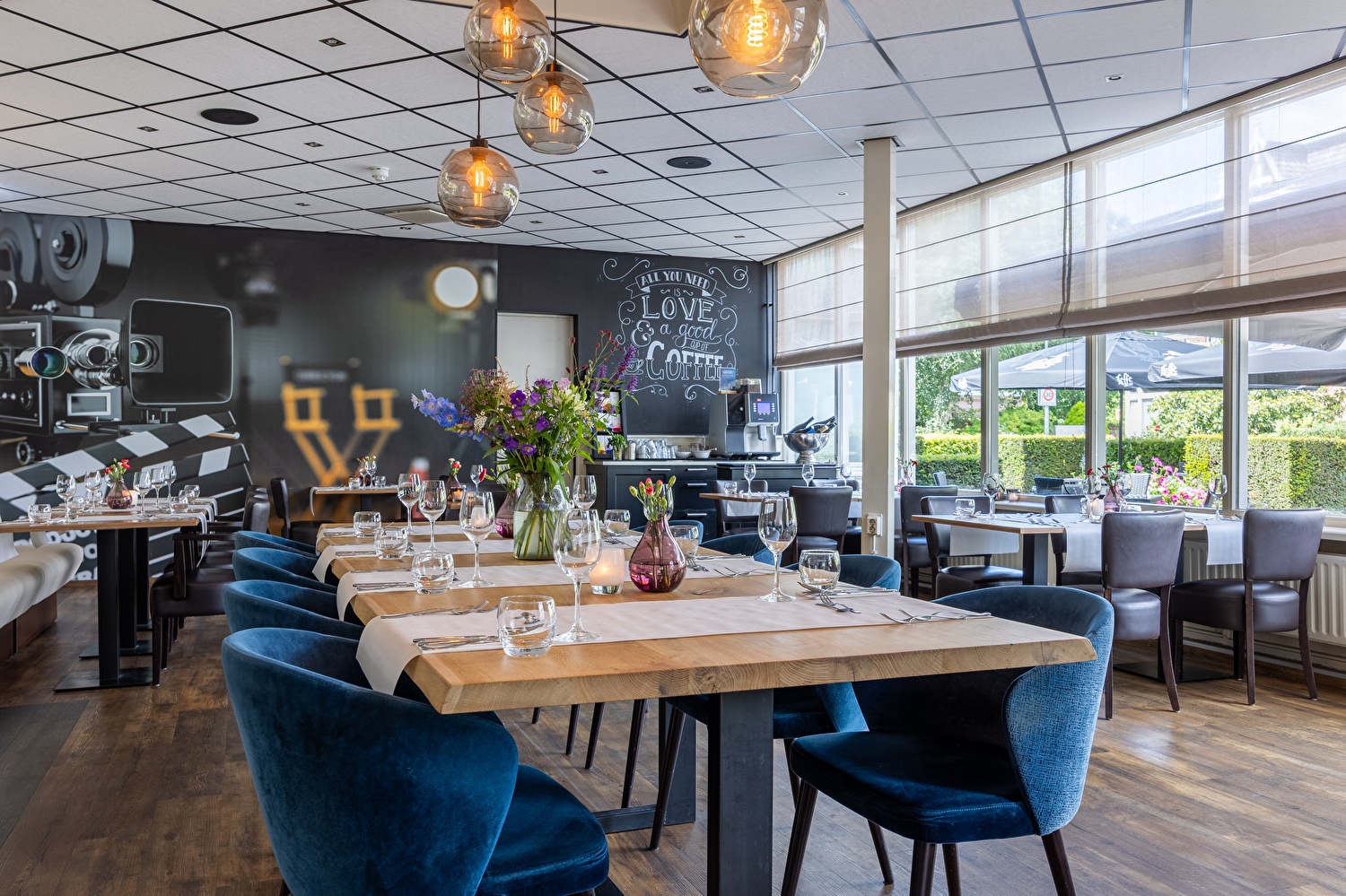 Restaurant in Amrâth Hotel Media Park Hilversum met tafels en stoelen in een ruimte met veel daglicht.