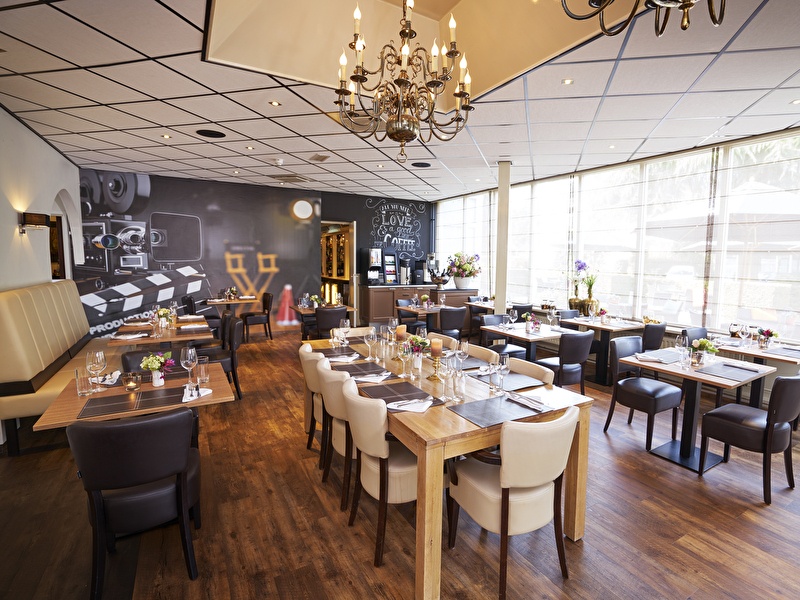 Lichte en moderne restaurantruimte met verschillende zitplaatsen in Amrâth Hotel Mediapark.   Bronnen en gerelateerde content