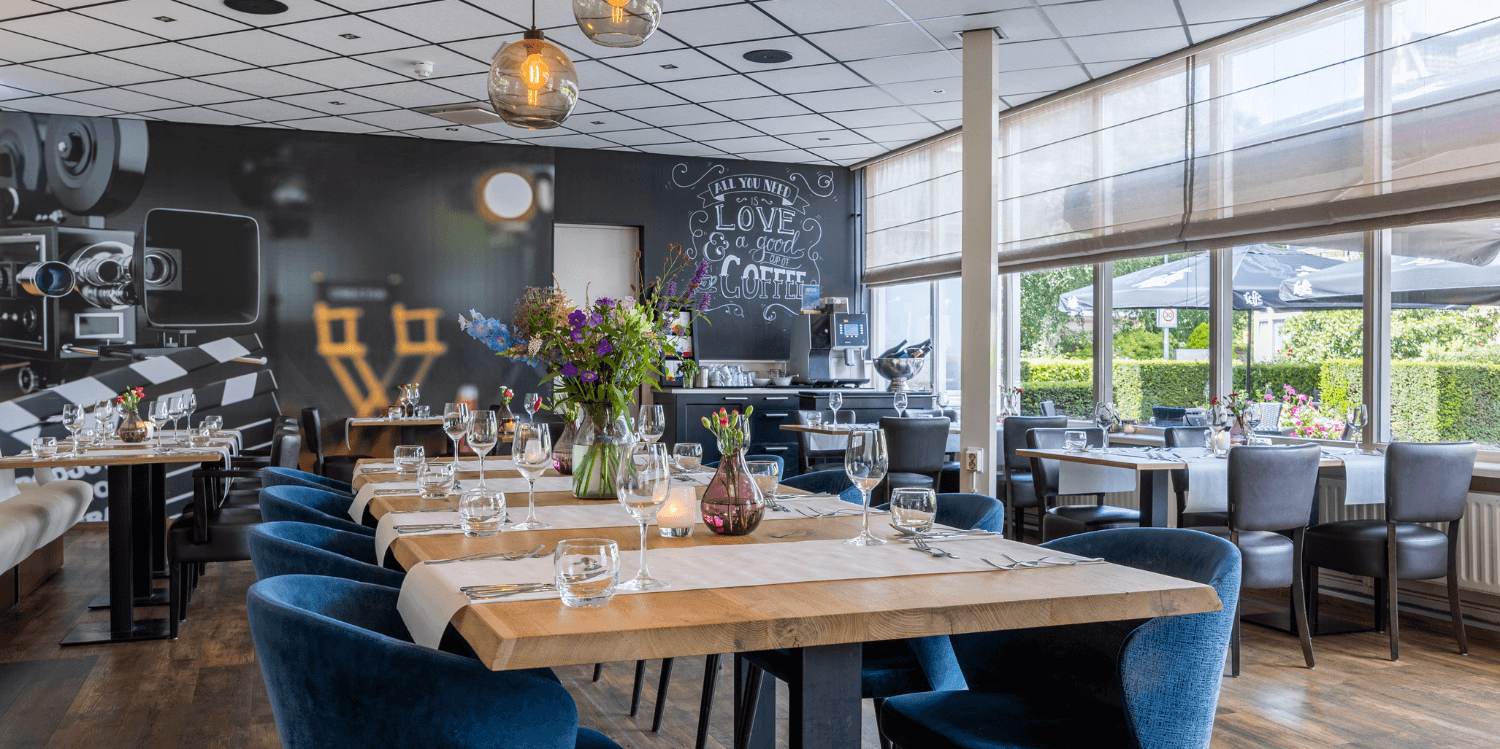 Restaurant in Amrâth Hotel Media Park Hilversum with tables and chairs in a space with plenty of daylight.