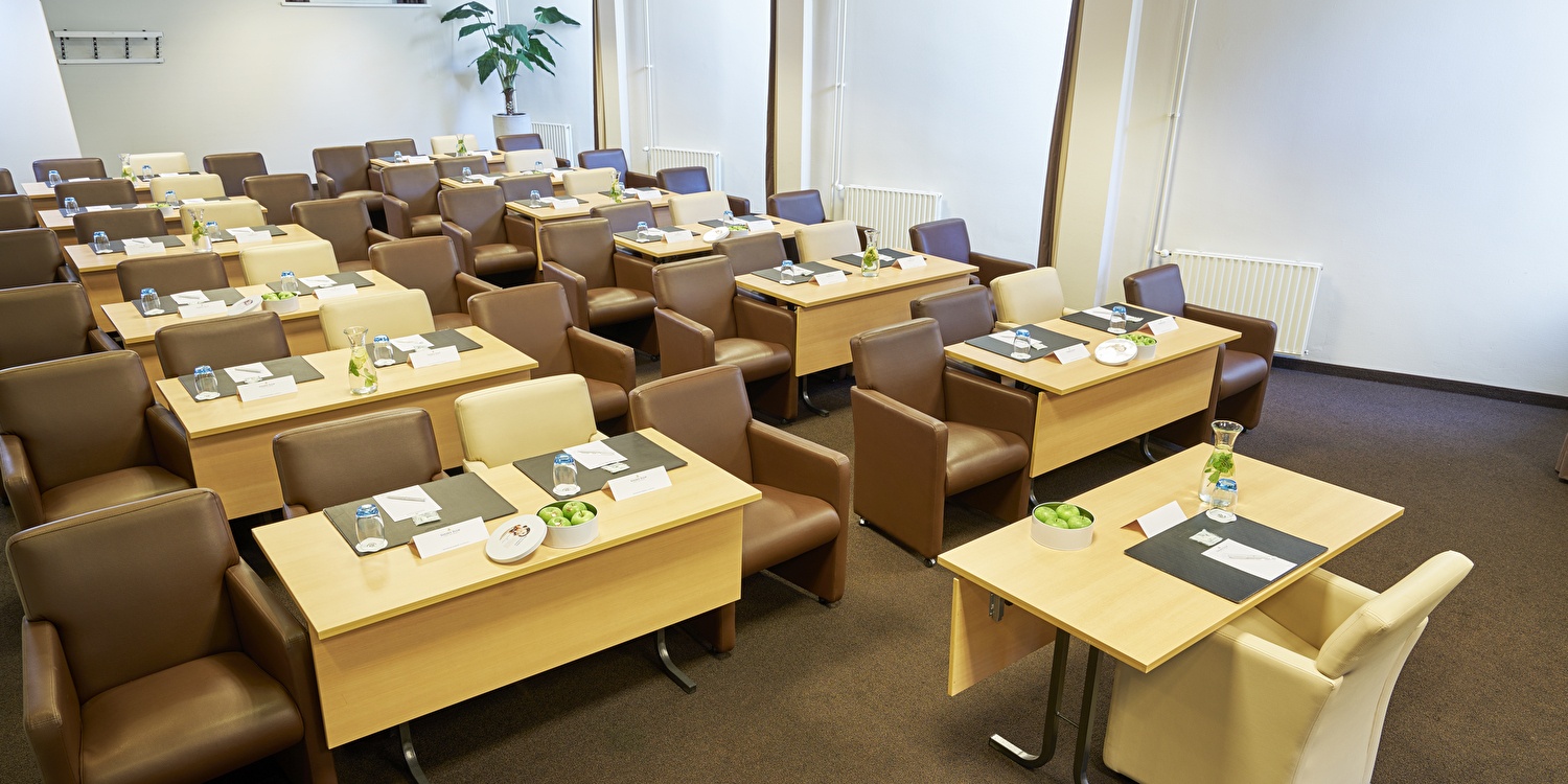 Een ruime vergaderzaal met een centrale tafel, perfect voor bijeenkomsten en vergaderingen.